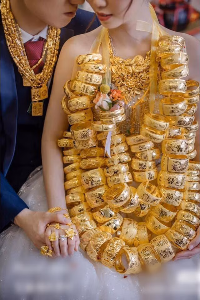 Hình ảnh cô dâu đeo khoảng 100 chiếc vòng làm bằng vàng khiến không ít người trầm trồ. Đây quả thực là đám cưới siêu khủng hiếm có từ trước tới nay.