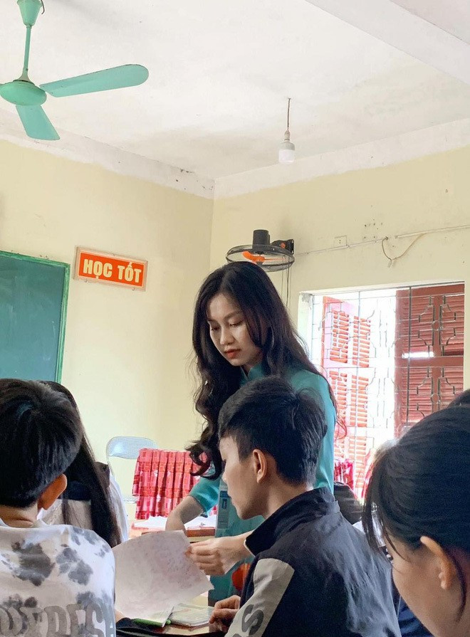 Cô giáo trẻ diện áo dài xanh, mái tóc xoăn dài được xõa nhẹ nhàng. Ở một số bức ảnh, cô mỉm cười tươi tắn, vô cùng thân thiện với học sinh.