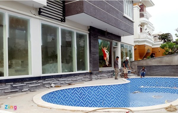 Phía cổng sau biệt thự thiết kế hiện đại với bể bơi. Các phòng khách, ngủ được lắp cửa kính, che rèm. Ảnh: Zing.