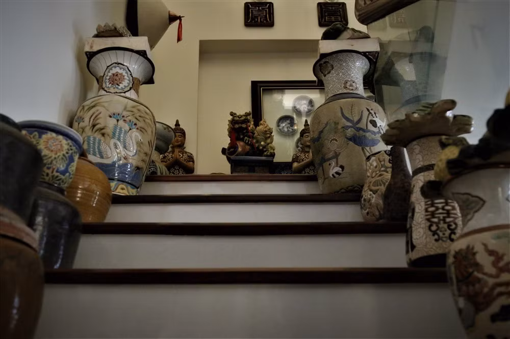 Các món đồ gốm sứ được sắp xếp khéo léo trong không gian nhà chật hẹp. Nhiều cổ vật còn được bày ở bên bên bậc cấp cầu thang. Ảnh: Lao động.