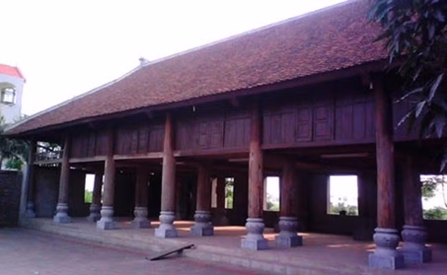 Xây dựng trên diện tích rộng tới vài héc ta, ngay đầu biệt phủ, giáp mặt đường liên xã là ngôi nhà sàn cực lớn với 24 cột gỗ lim, đế đá. Cột gỗ lim này lớn đến mức một người ôm không xuể. Ảnh: Dân Việt.