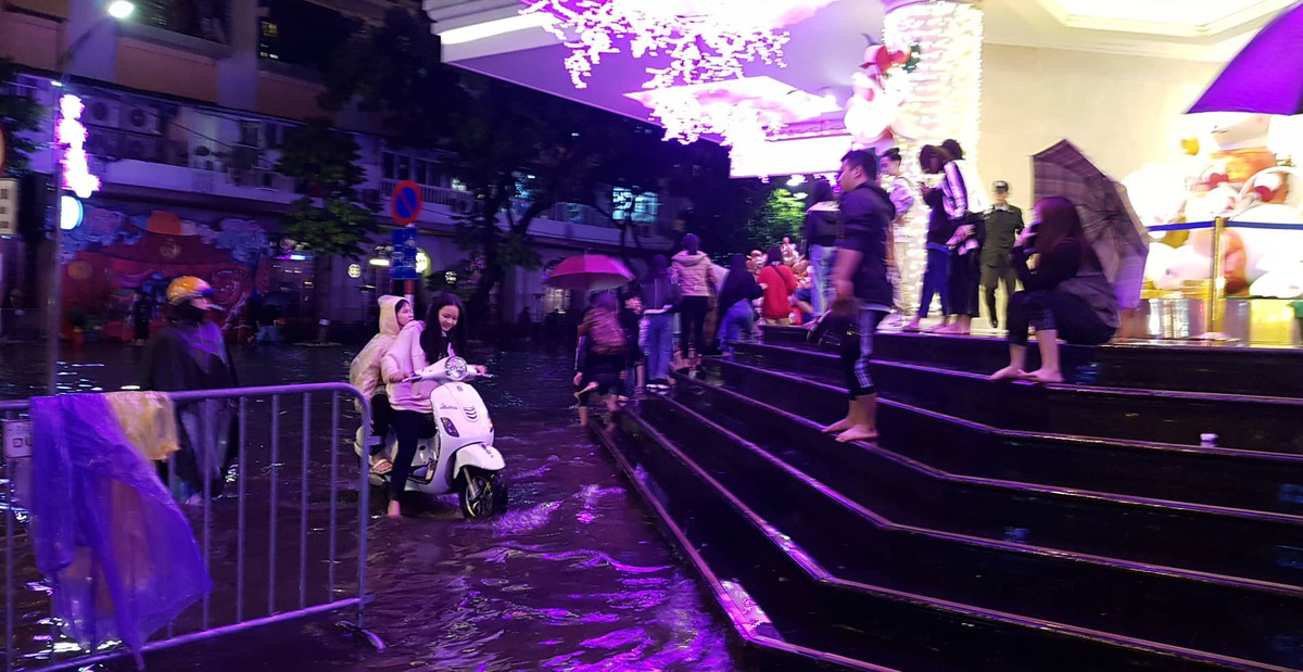 Một số bạn trẻ đổ về trung tâm thành phố để xem pháo hoa nhưng mưa to và đường ngập đành tìm nơi trú.