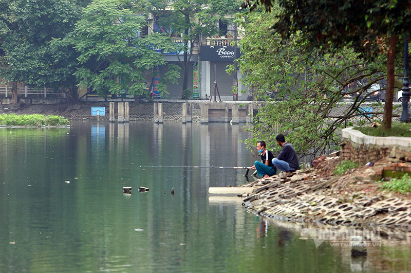 Trong khi công an phường, lực lượng dân phòng liên tục nhắc nhở người đi bộ quanh hồ về nhà thì không phát hiện ra số cần thủ đang ngồi câu nơi đây