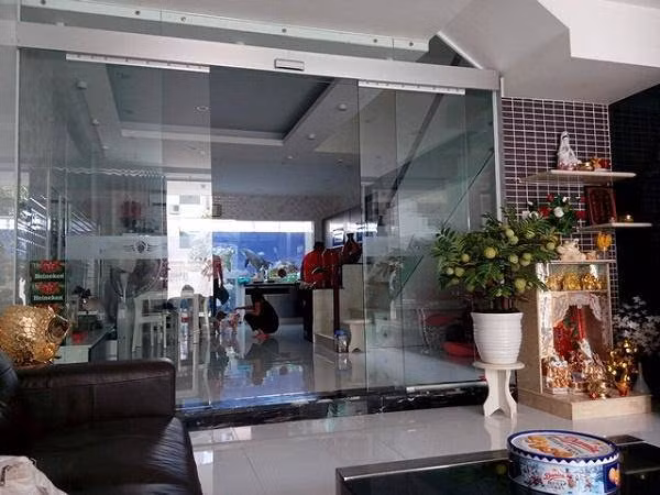 Cửa ra vào chính và lan can cầu thang trong biệt thự đều được thiết kế bằng kính trong suốt.