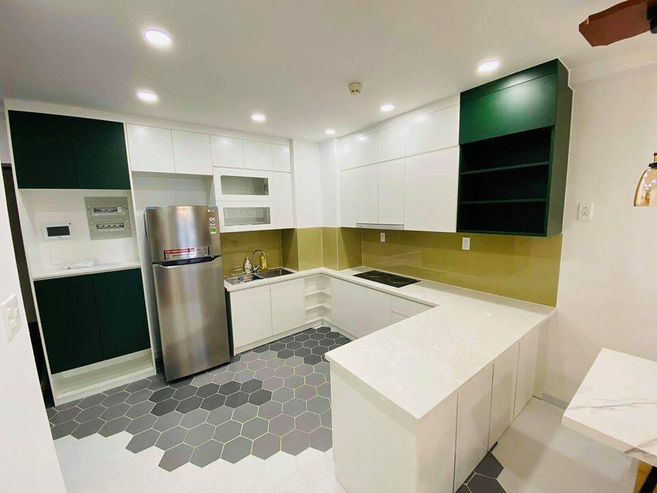 Khu bếp nổi bật với gam màu trắng chủ đạo kết hợp sàn lát gạch họa tiết hình học.