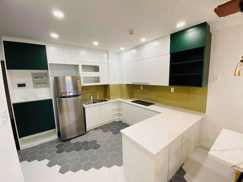 Khu bếp nổi bật với gam màu trắng chủ đạo kết hợp sàn lát gạch họa tiết hình học.