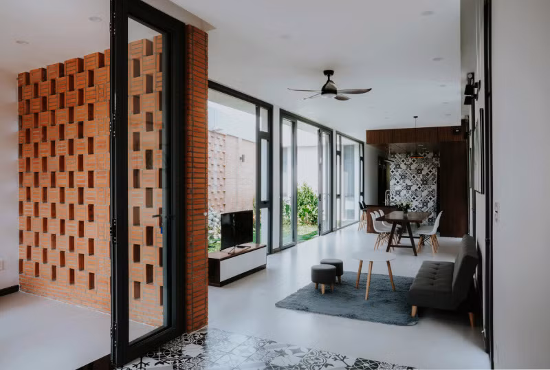 Nhà sử dụng gạch thô làm vật liệu chủ đạo kết hợp với gỗ óc chó tự nhiên trên nền sơn trắng. Ảnh: Cung Vit.