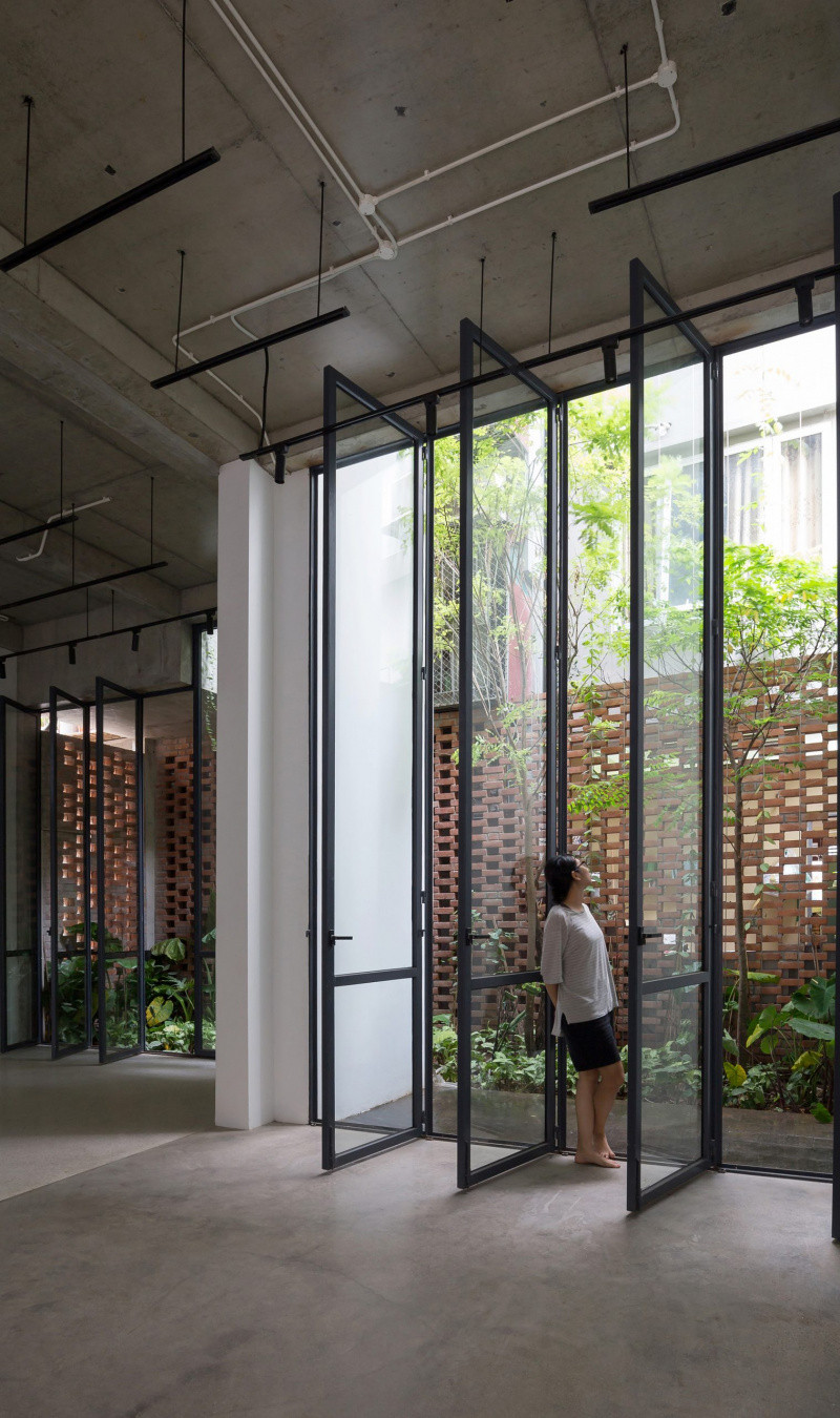 Hai lớp mặt tiền căn nhà gồm lớp ngoài bằng gạch xếp tạo lỗ và lớp trong bằng kính khung sắt. Ảnh: Hoàng Lê.