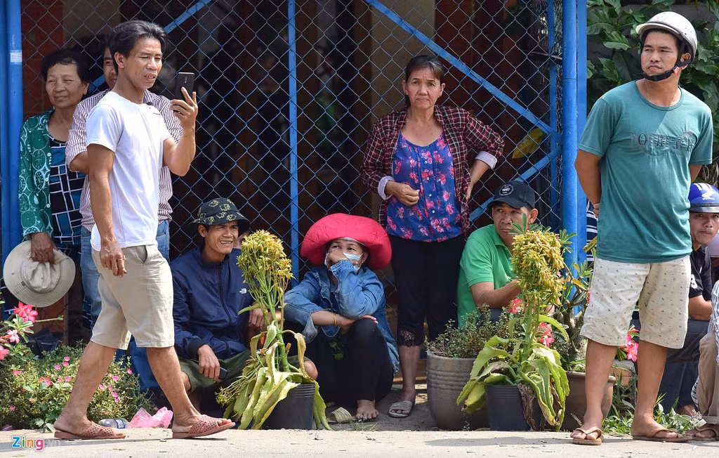 Người đàn ông sử dụng điện thoại ghi lại hình ảnh cảnh sát vây bắt nghi can.