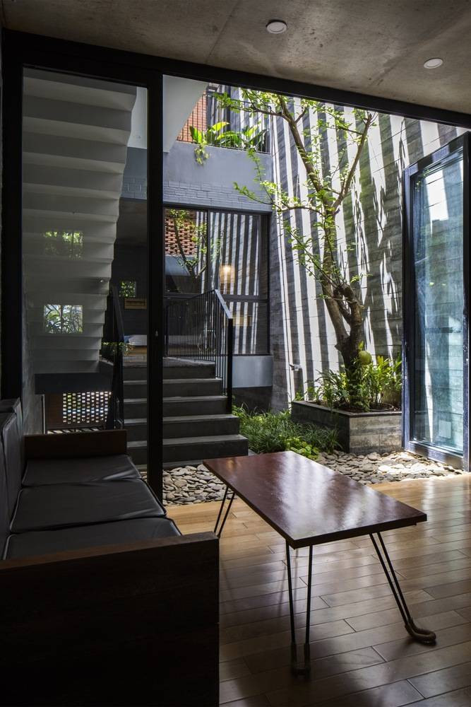 Phòng khách tối giản chỉ gồm bàn và sofa văng gỗ.