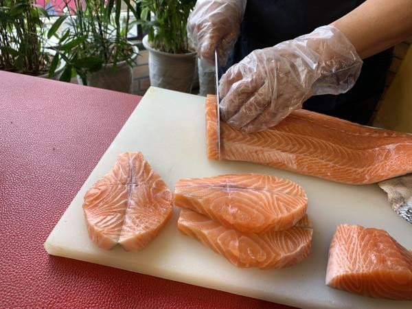 Người làm bánh sẽ tẩm ướp cá hồi bằng phương thức đặc biệt để khi luộc bánh không làm mất đi vị truyền thống bởi mùi tanh của cá. Ảnh: VTC