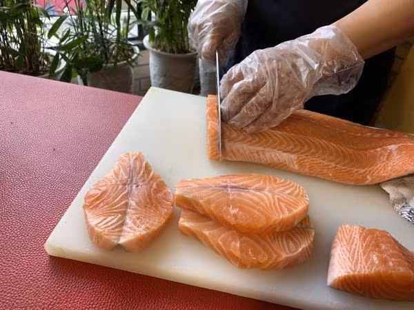 Người làm bánh sẽ tẩm ướp cá hồi bằng phương thức đặc biệt để khi luộc bánh không làm mất đi vị truyền thống bởi mùi tanh của cá. Ảnh: VTC