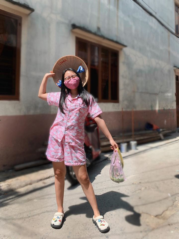 Phương Mỹ Chi tạo dáng đáng yêu, đeo khẩu trang cẩn thận đi chợ dù chợ rất gần nhà. Ca sĩ 17 tuổi kêu gọi sử dụng khẩu trang vải vì tiện dụng, an toàn và tiết kiệm.