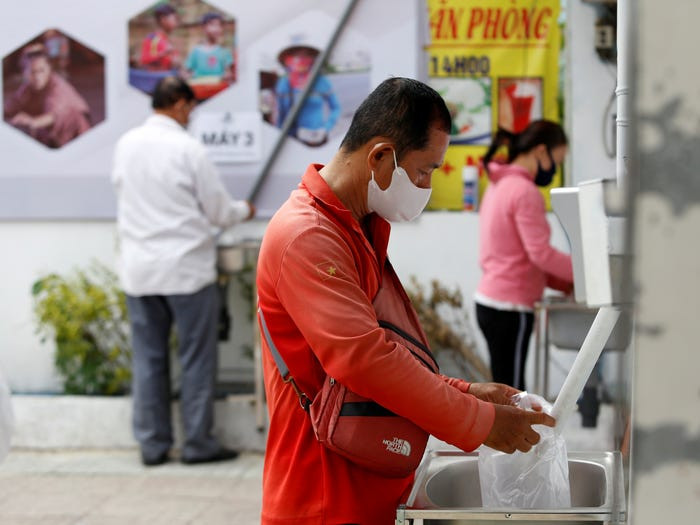 Nhiều người đến nhận gạo miễn phí là những người bán hàng rong, bán vé số. Ảnh: Reuters.