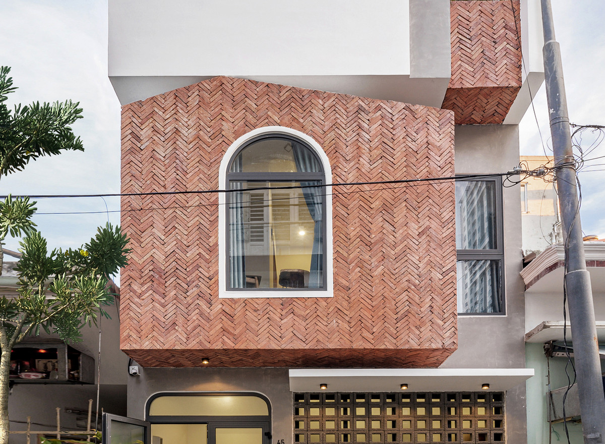 Vì vậy, kiến trúc sư sử dụng cây xanh kết hợp các vật liệu tông màu thô: tông gạch đỏ, tường xi măng bên ngoài để vẽ một mặt ngoài thật tự nhiên mộc mạc.