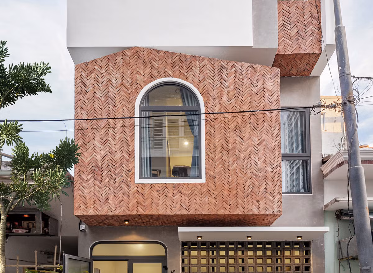 Vì vậy, kiến trúc sư sử dụng cây xanh kết hợp các vật liệu tông màu thô: tông gạch đỏ, tường xi măng bên ngoài để vẽ một mặt ngoài thật tự nhiên mộc mạc.