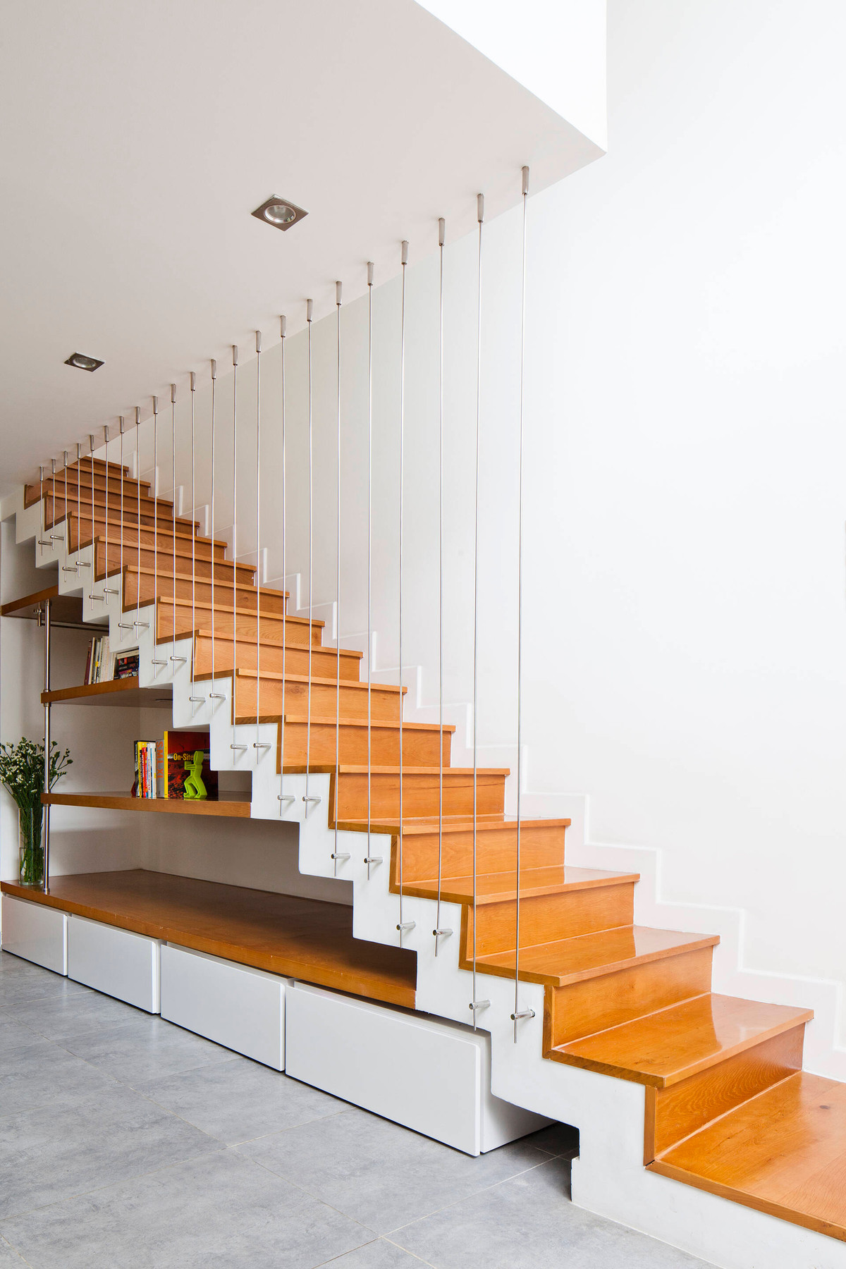 Gầm cầu thang được tận dụng làm nơi để giá sách.