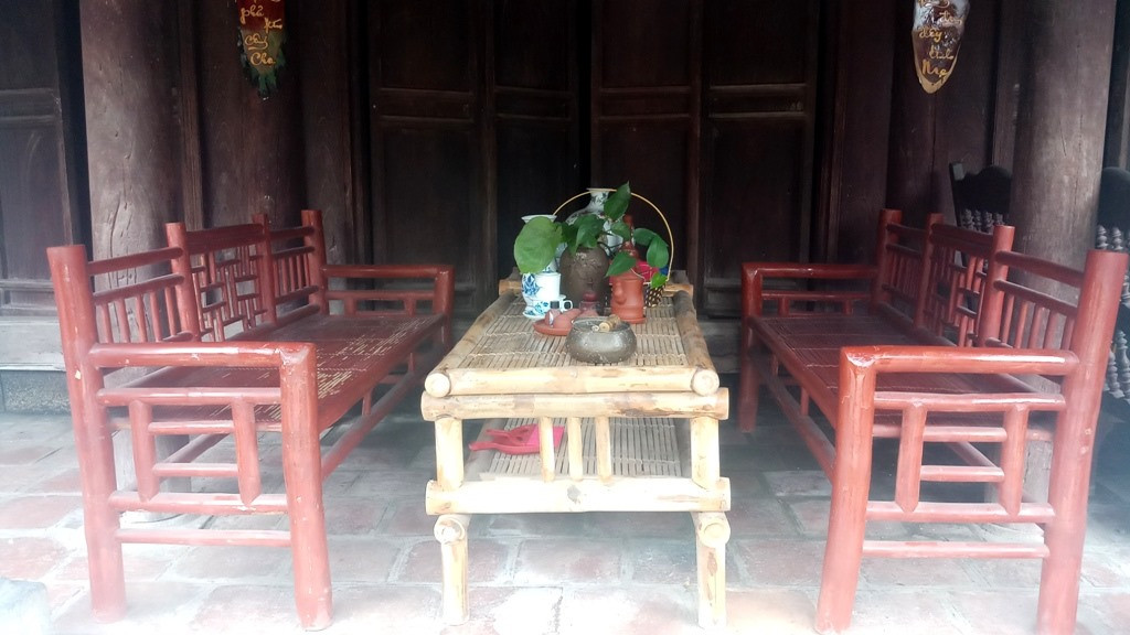 Ngay trước hiên nhà là bàn uống nước được làm bằng tre và trang bị các vật dụng như ấm trà, cơi trầu. Ảnh: Lao động.