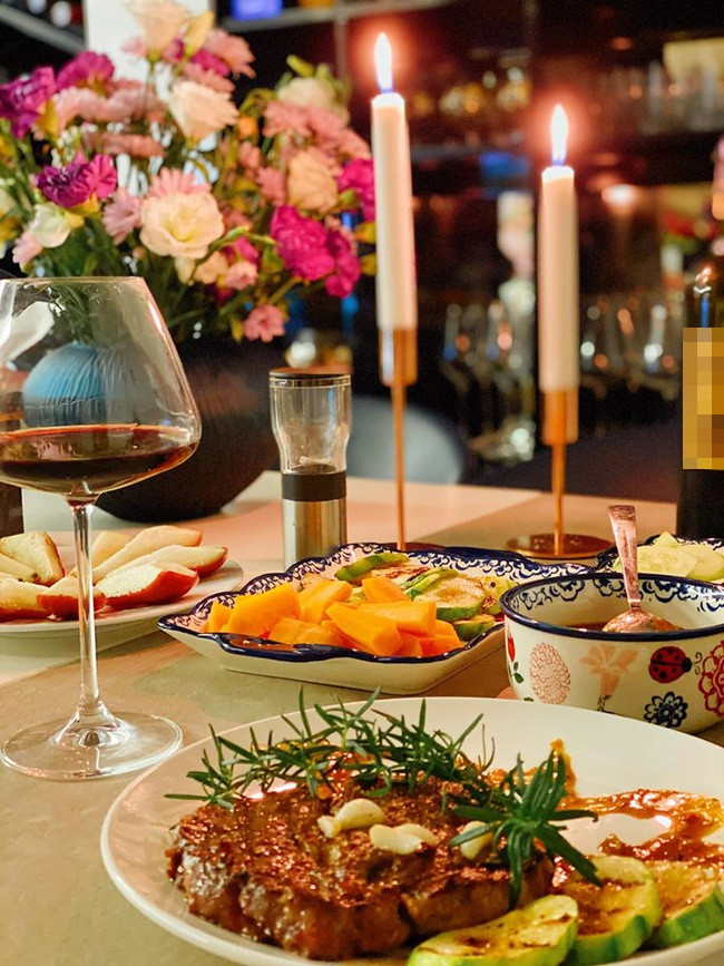 Bữa ăn gồm bò bít tết, salad, rượu vang,... đúng chuẩn phong cách phương Tây và trang trí sang trọng chẳng kém nhà hàng.