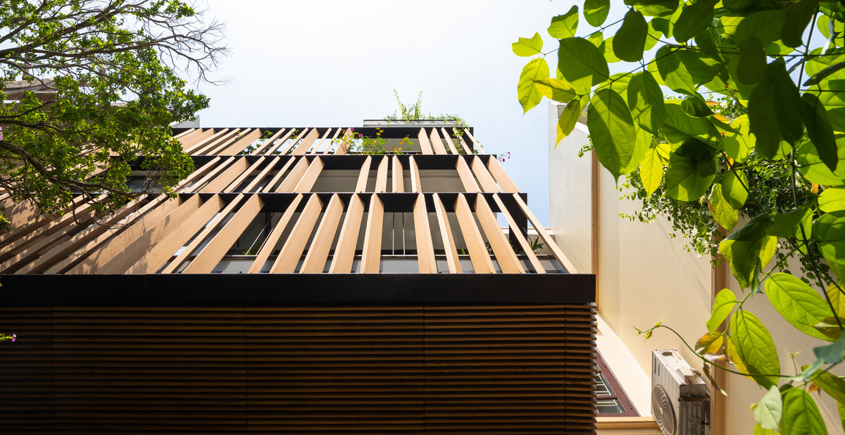 Mặt tiền hướng Tây được thiết kế với hệ thống lam gỗ, ngoài việc giảm bức xạ mặt trời còn đóng vai trò định hình tòa nhà.