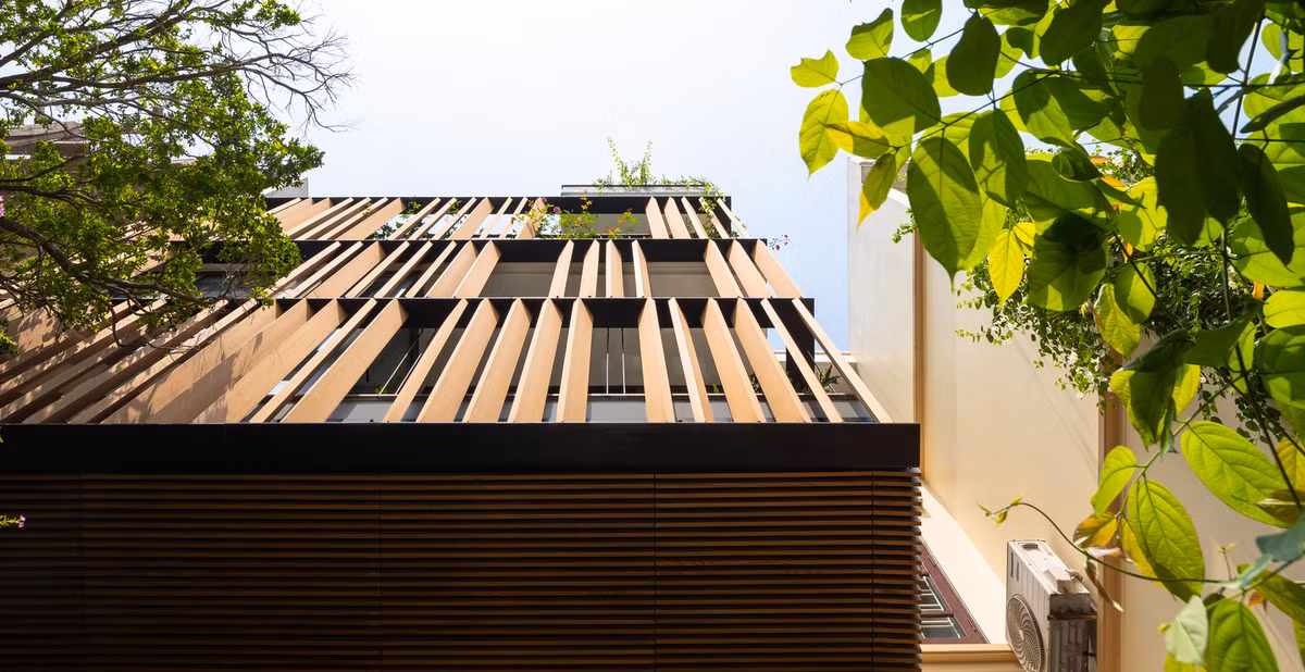 Mặt tiền hướng Tây được thiết kế với hệ thống lam gỗ, ngoài việc giảm bức xạ mặt trời còn đóng vai trò định hình tòa nhà.