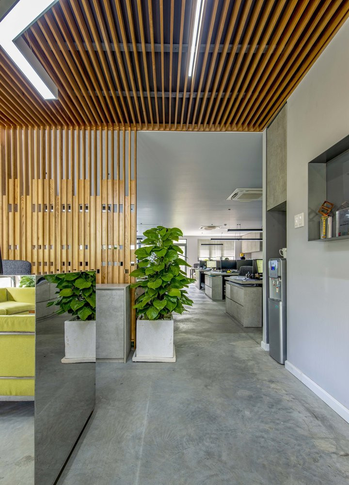 Vách ngăn bằng gỗ màu sáng tạo cảm giác ấm áp, xua tan vẻ lạnh lẽo của tường và sàn bê tông xám.