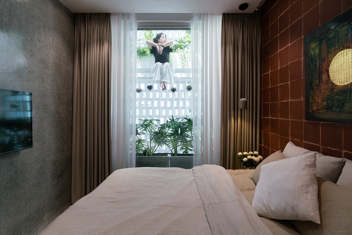 Phòng ngủ đón được ánh sáng tự nhiên nhờ bức tường lỗ phía sau.