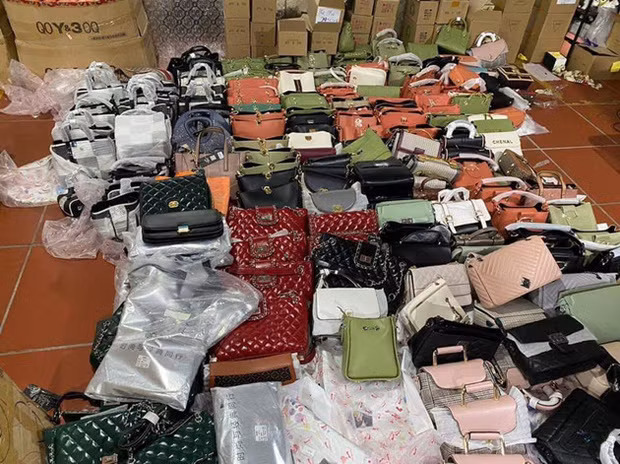 Những chiếc túi xách nghi làm giả các nhãn hiệu nổi tiếng. Ảnh: Báo Bảo vệ pháp luật