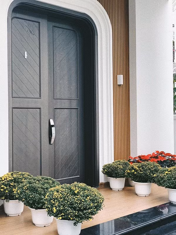 Lối vào căn nhà trang trí nhiều hoa tươi. Ảnh: Khám phá.