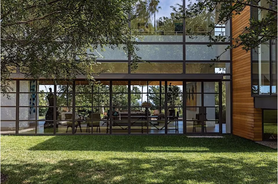 Căn nhà có tới 5 phòng ngủ và 13 phòng tắm được thiết kế vô cùng tinh tế. Bao quanh ngôi nhà là những tấm kính hiện đại trong suốt có thể nhìn xuyên nội thất bên trong.