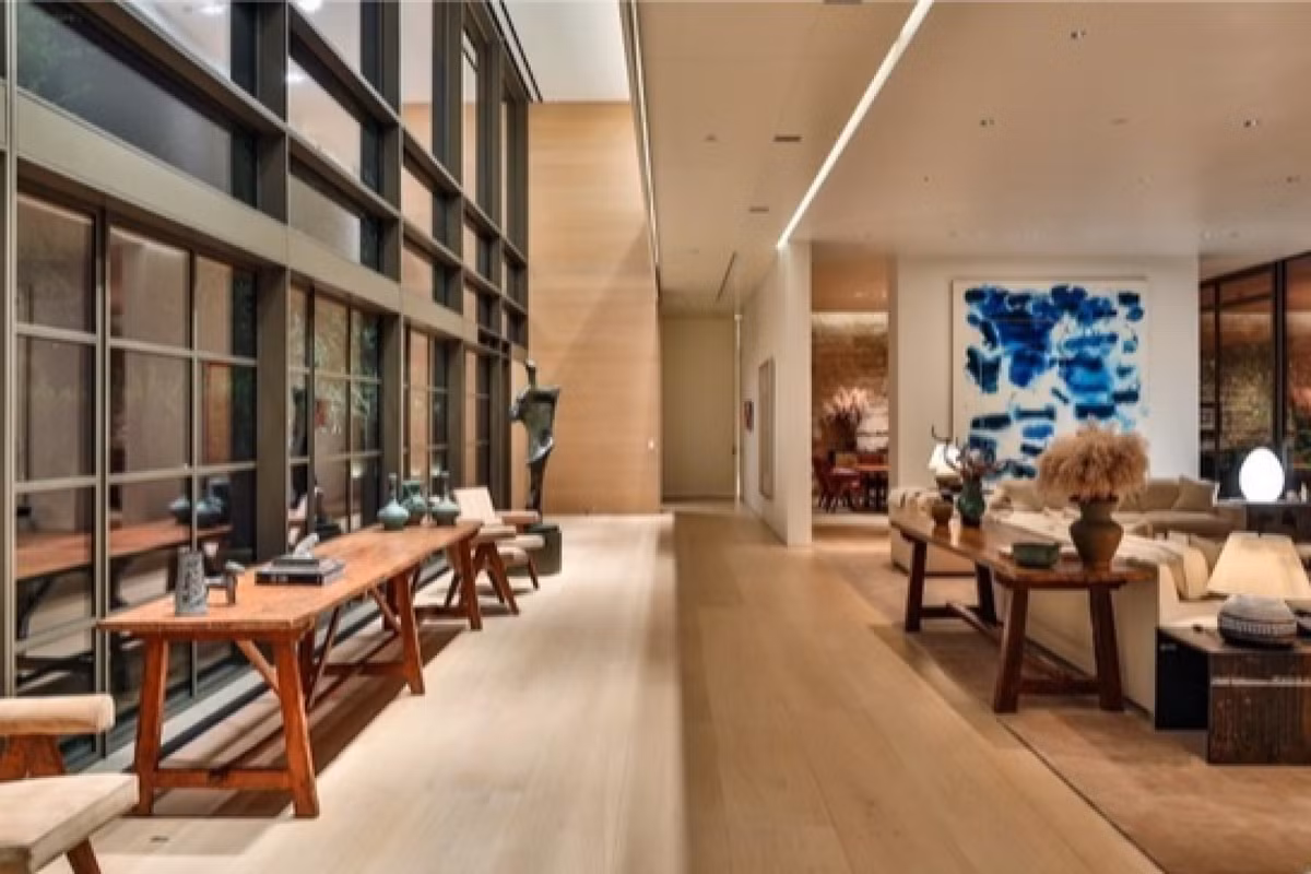 Bên cạnh những ô cửa sổ lớn, phòng khách có kê thêm những chiếc bàn gỗ dài để trưng bày những đồ vật lưu niệm.