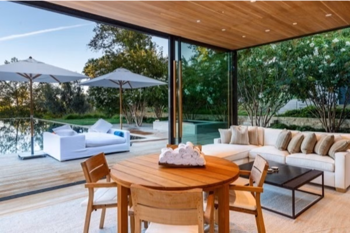 Bên cạnh hồ bơi, bộ bàn ghế xinh đẹp được sắp xếp ngay ngắn trong không gian nhà kính, làm tăng thêm sự tiên nghi cho căn nhà.