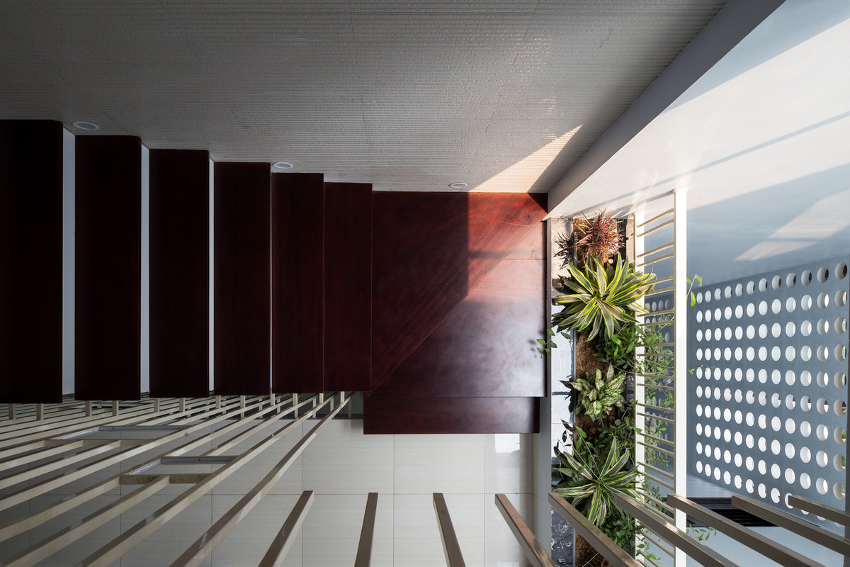 Khoảng trống sau nhà nằm cạnh cầu thang kết hợp với mảng tường gạch bông gió giúp hạn chế ánh nắng, đảm bảo riêng tư và an ninh cho ngôi nhà.