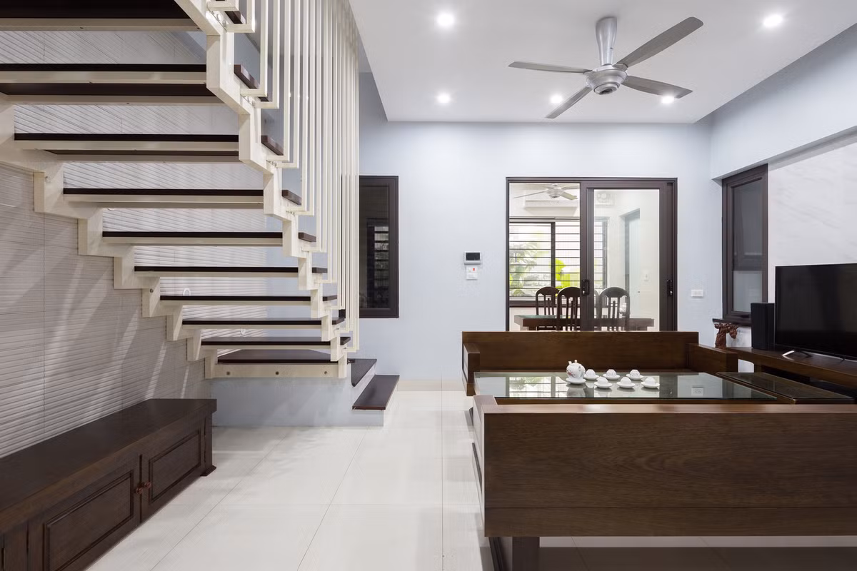 Cầu thang thiết kế áp vào tường để tiết kiệm diện tích và tăng tính kết nối giữa các không gian.