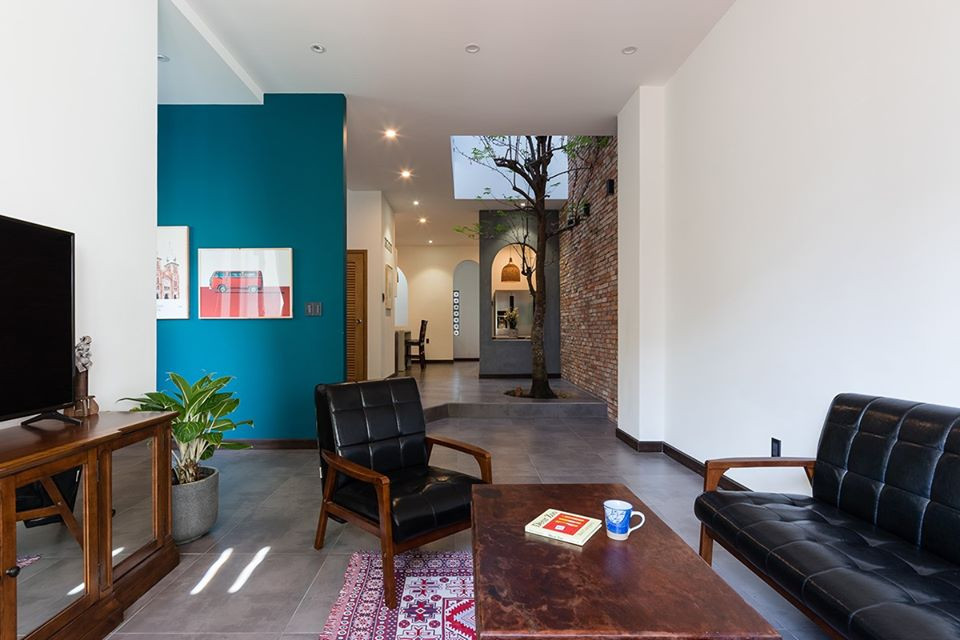 Nội thất gỗ tối màu cùng với vài chậu cây tạo mảng xanh đầy chất thơ.