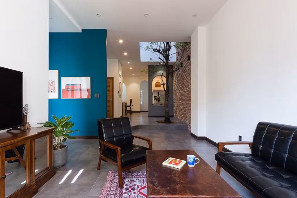 Nội thất gỗ tối màu cùng với vài chậu cây tạo mảng xanh đầy chất thơ.