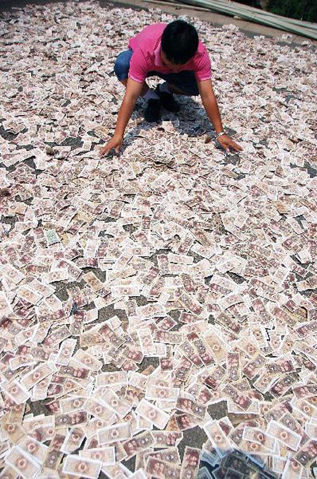 Tiền nhiều chất lâu trong nhà sợ ẩm mốc, một người đàn ông tên Yang, tại Quý Châu, Trung Quốc lâu lâu lại mang số tài sản rải trắng mặt sân hong nắng.