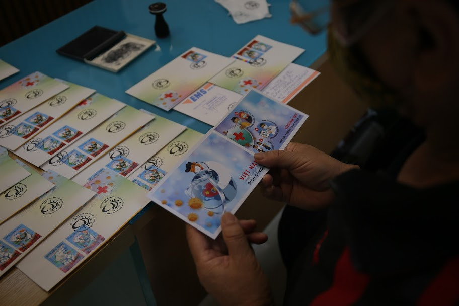 Mẫu tem giá mặt 15.000đ thể hiện hình ảnh các bác sĩ của Việt Nam đang ngày đêm nỗ lực để nghiên cứu, tìm ra các phác đồ điều trị tốt nhất để cứu chữa kịp thời cho bệnh nhân và quyết tâm nghiên cứu vắc-xin để đẩy lùi đại dịch COVID-19, được coi là một sứ mệnh cao cả.