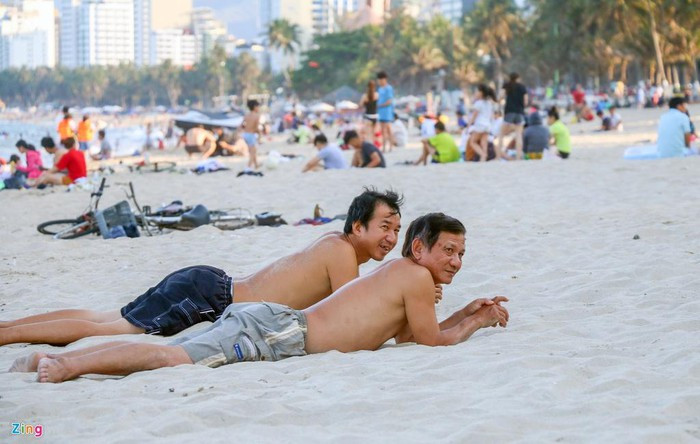 Bãi biển trước khu vực các khách sạn Yasaka, Nha Trang Center, Havana Nha Trang, Lodge... luôn kín mít. "Trời nắng nóng nên ra đây hóng mát. Cũng không lo lắng lắm vì Nha Trang đã hết dịch Covid-19 rồi", anh Vinh, ngụ TP Nha Trang cho biết.