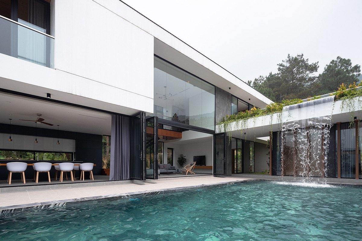 Điểm nhấn của căn biệt thự là một thác nước nhân tạo đổ xuống bể bơi, tạo ra cảnh quan ngoạn mục.