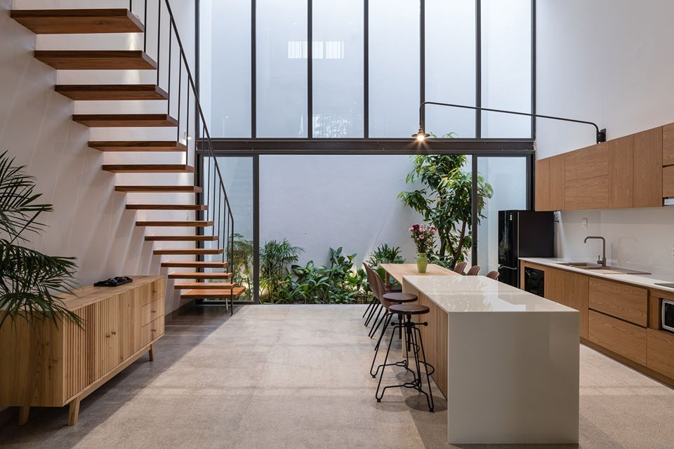 Phòng bếp ngập ánh sáng và thoáng khí nhờ sự kết hợp khéo léo giữa khoảng thông tầng và cửa kính lớn.