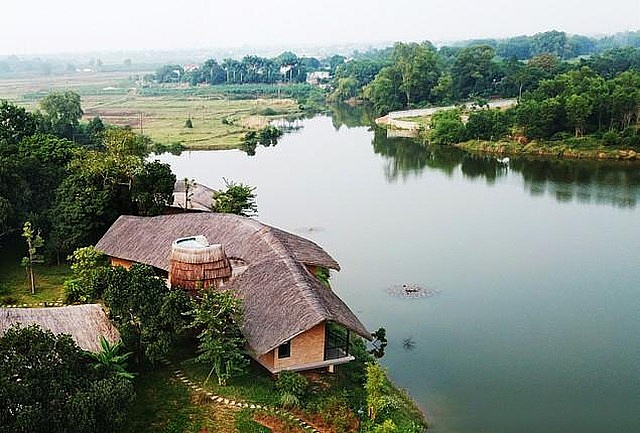 Với thiết kế mái lớp rạ và sự kết hợp đặc biệt giữa truyền thống và hiện đại, thoải ra hồ, tầm nhìn rộng thoáng, ngôi nhà nương vào cây cối một cách tự nhiên. Nguồn: Báo Xây Dựng.