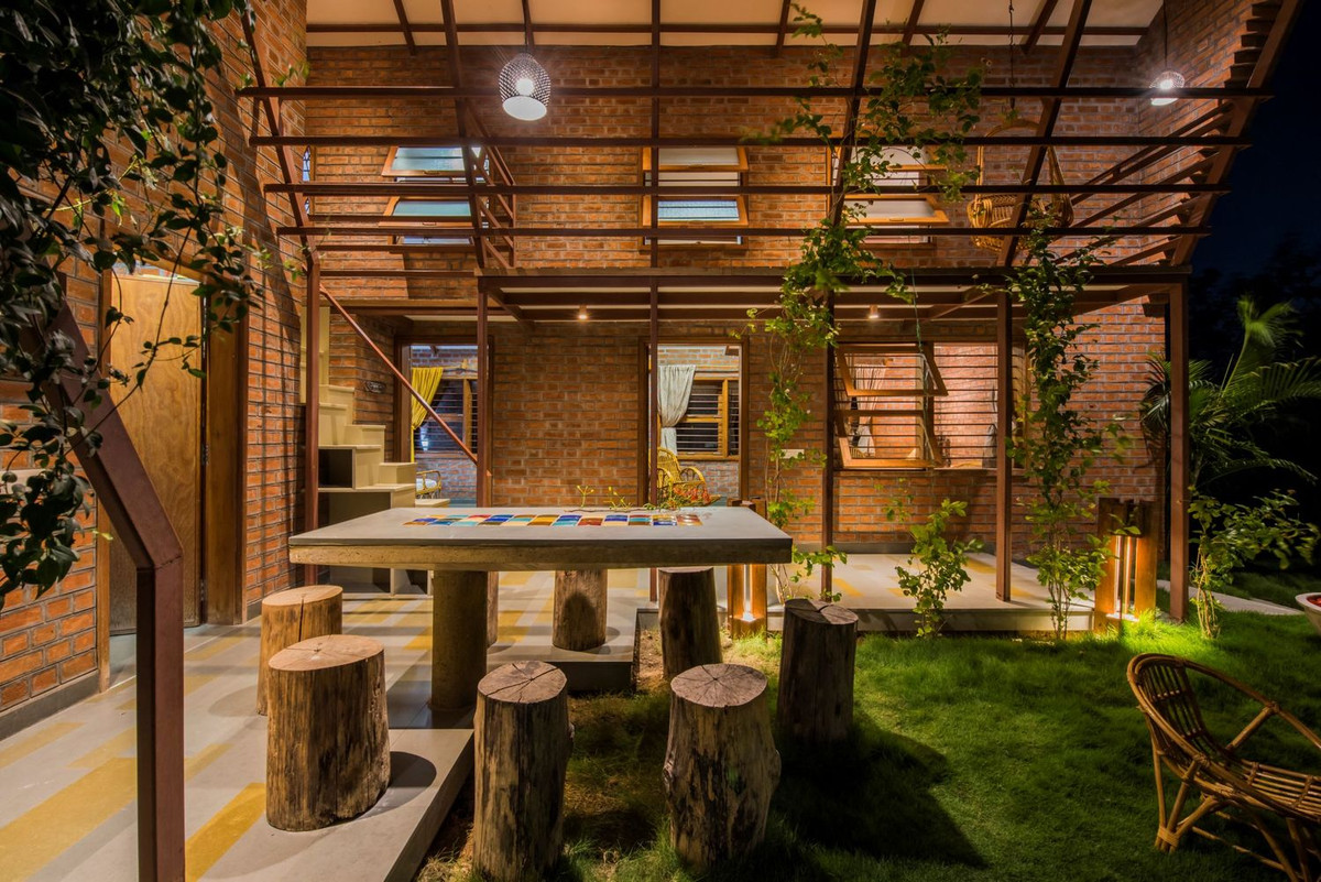 Nhà thiết kế đơn giản có 2 tầng. Tầng 1 là khu vực bàn ăn ngoài trời, bếp, phòng khách và phòng ngủ nhỏ.