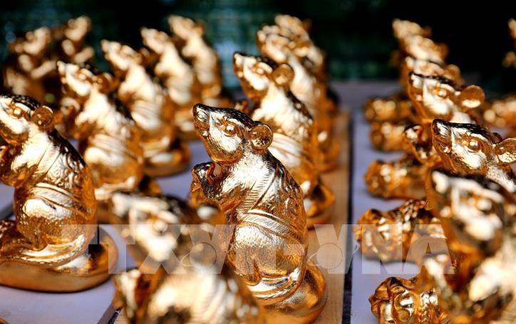 Tại làng gốm Bát Tràng, gốm chuột dát vàng đang được các nghệ nhân gấp rút hoàn thiện để phục vụ khách năm nay. Ảnh: TTXVN.