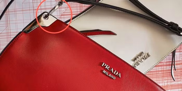 các khóa kéo, logo và móc cài trên túi xách Peada đều đồng màu. Ngoài ra, tên thương hiệu Prada được khắc trên móc cài. Túi xách nào không có thì là giả.