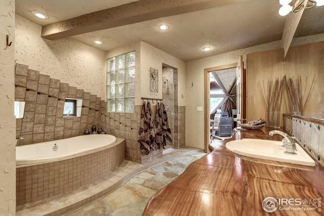 Phòng tắm chính lát sàn đá tự nhiên và tủ gỗ vừa tiện nghi vừa mang phong cách đồng quê, mộc mạc.