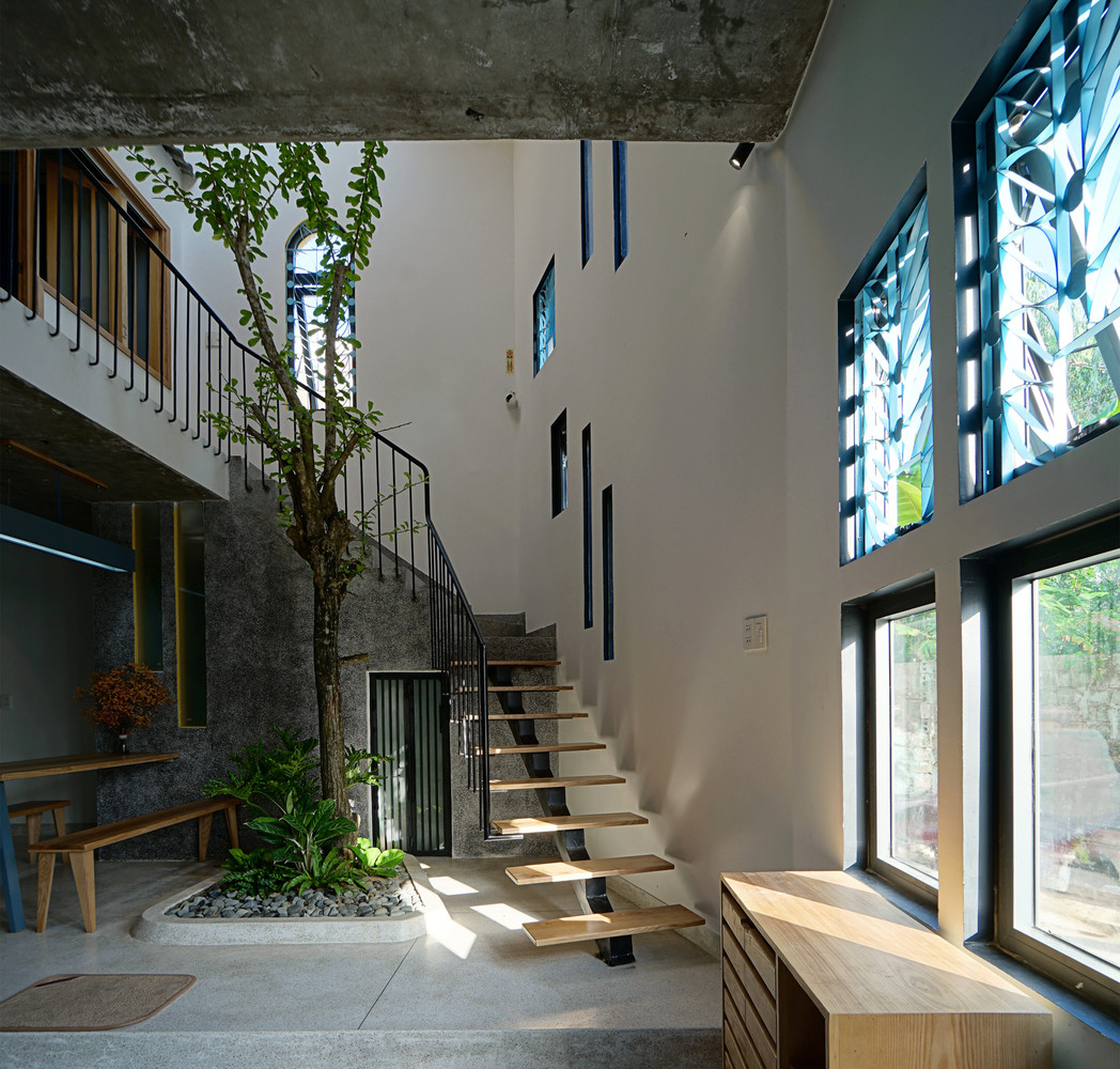 Để tối ưu hóa diện tích trên mảnh đất méo, kiến trúc sư chia nhà thành các ô vuông và tận dụng góc xéo làm khoảng thông tầng, toilet.