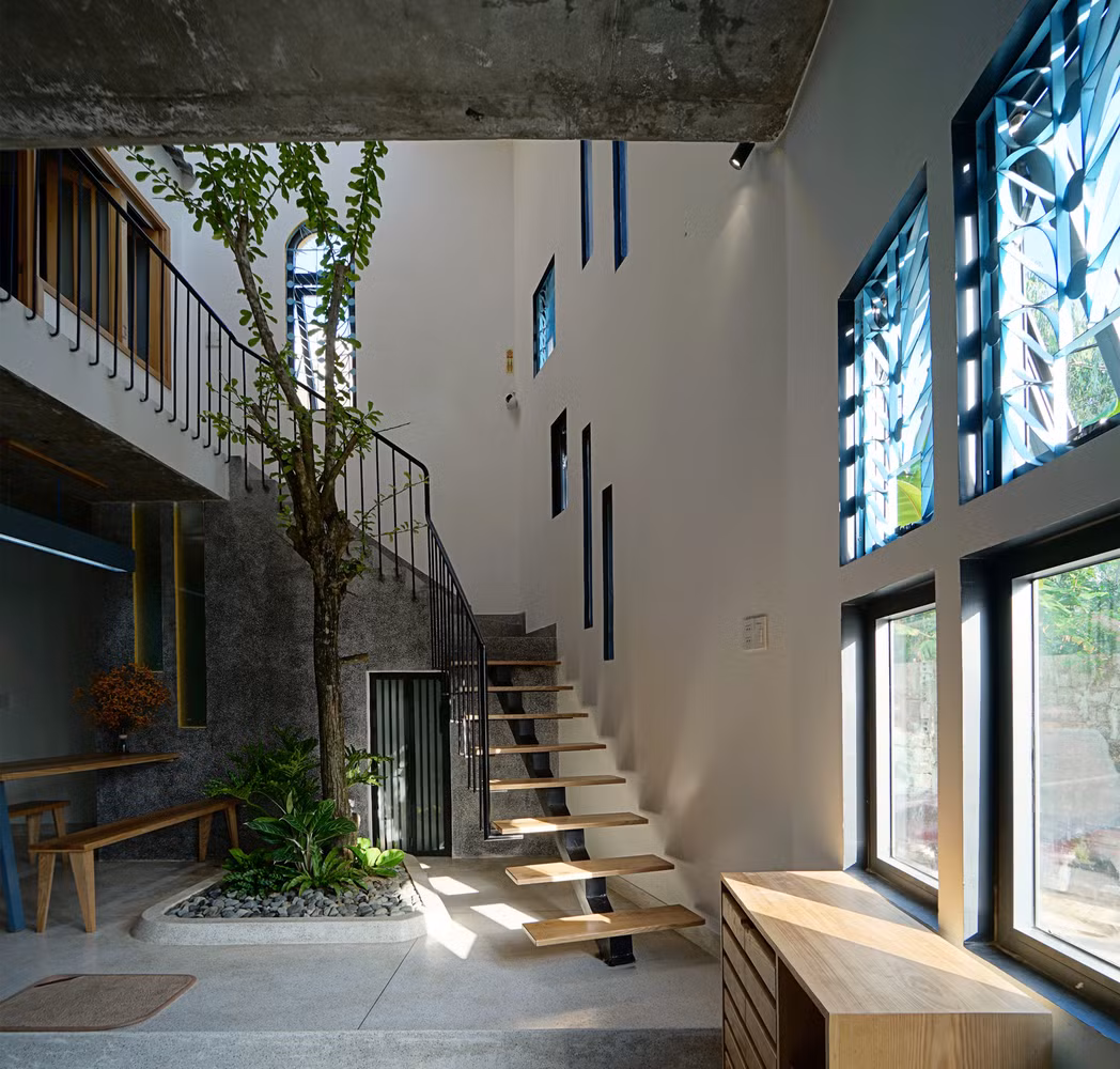 Để tối ưu hóa diện tích trên mảnh đất méo, kiến trúc sư chia nhà thành các ô vuông và tận dụng góc xéo làm khoảng thông tầng, toilet.