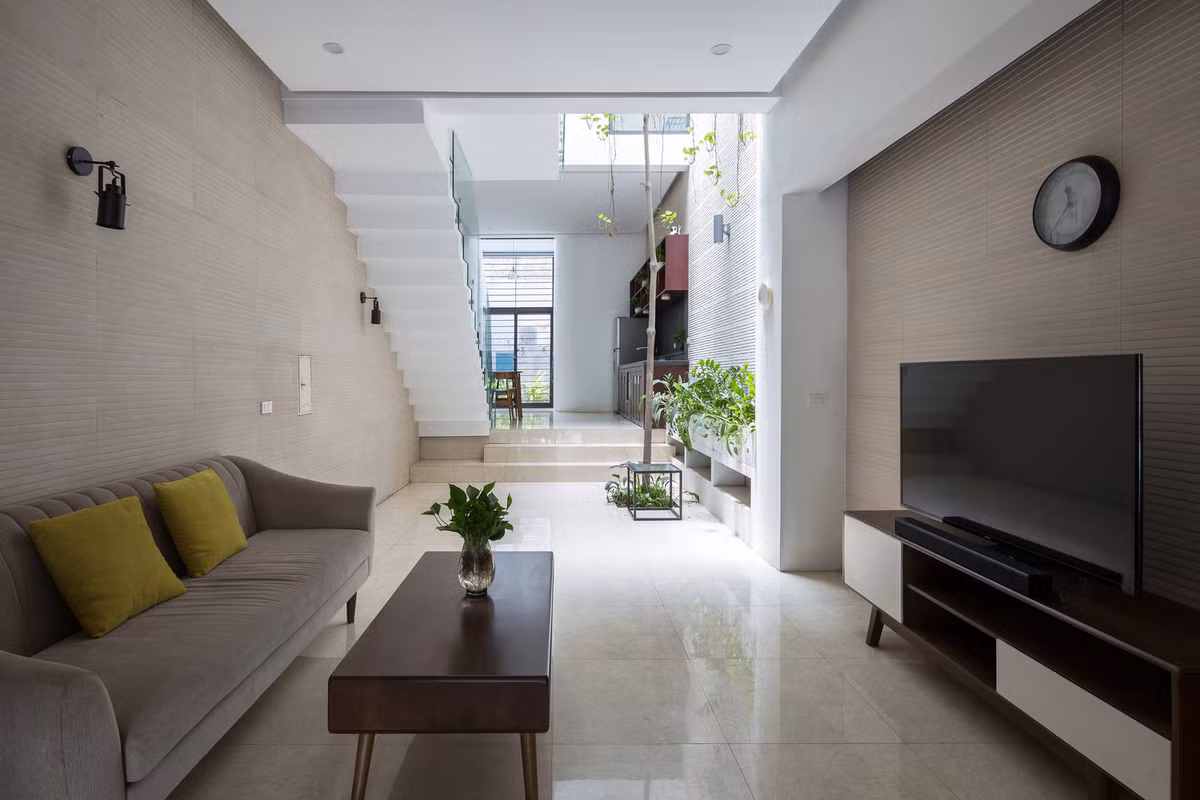 Theo đó, mặt tiền nhà được phát triển theo chiều dọc và có xu hướng đi sâu vào trong ở các tầng cao hơn. Giải pháp này đẩy không gian sinh hoạt ra phía sau để tạo không gian đệm ngoài trời ở phía trước.