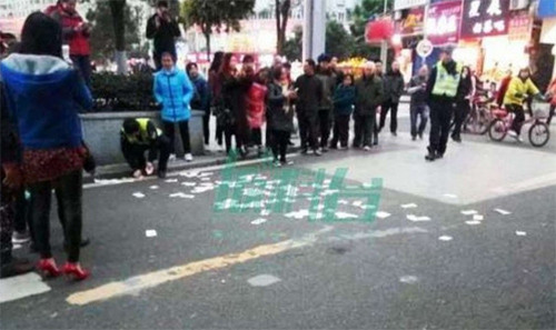 Cảnh sát sau đó nhanh chóng thu gom lại toàn bộ số tiền mặt do người phụ nữ vứt ra. Tổng cộng có 16.369 nhân dân tệ (khoảng 52 triệu đồng). Ảnh: Xinhua.
